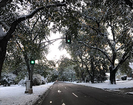 A view down 6th Avenue with snow on the grass.