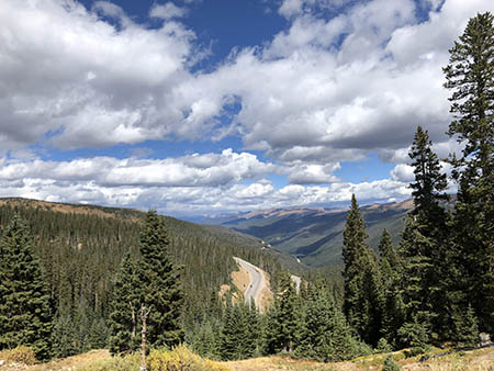 Overlook view of trees, mountains, and clouds.
