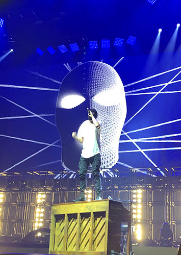 Picture of Tyler on top of his piano at a Twenty One Pilots concert.